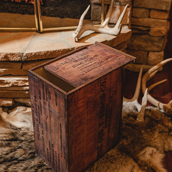 George T. Stagg wooden box with text on a stone surface with antlers and fur in the background.