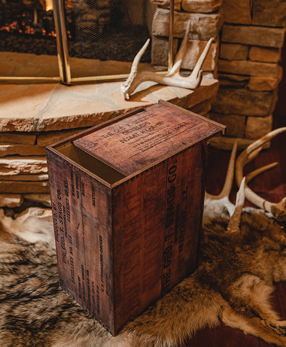 George T. Stagg wooden box with text on a stone surface with antlers and fur in the background.
